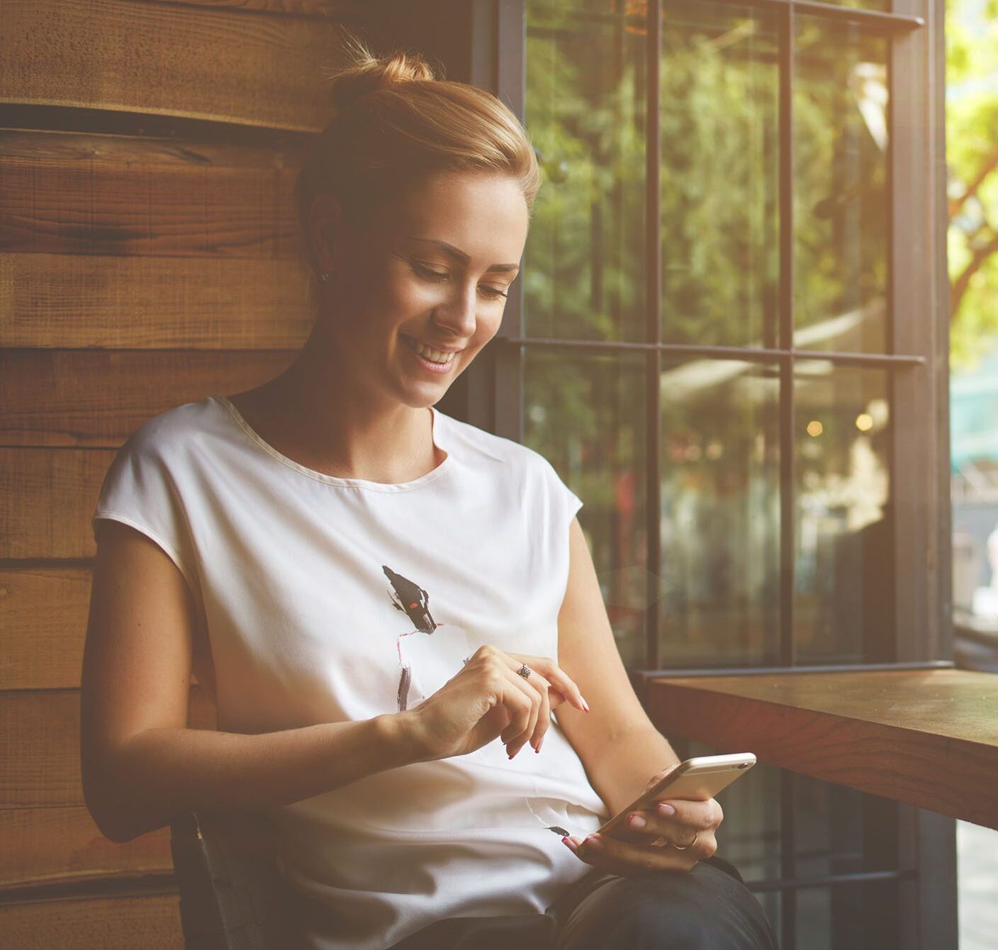 Young woman on mobile device | Stay Well Hotel Rewards