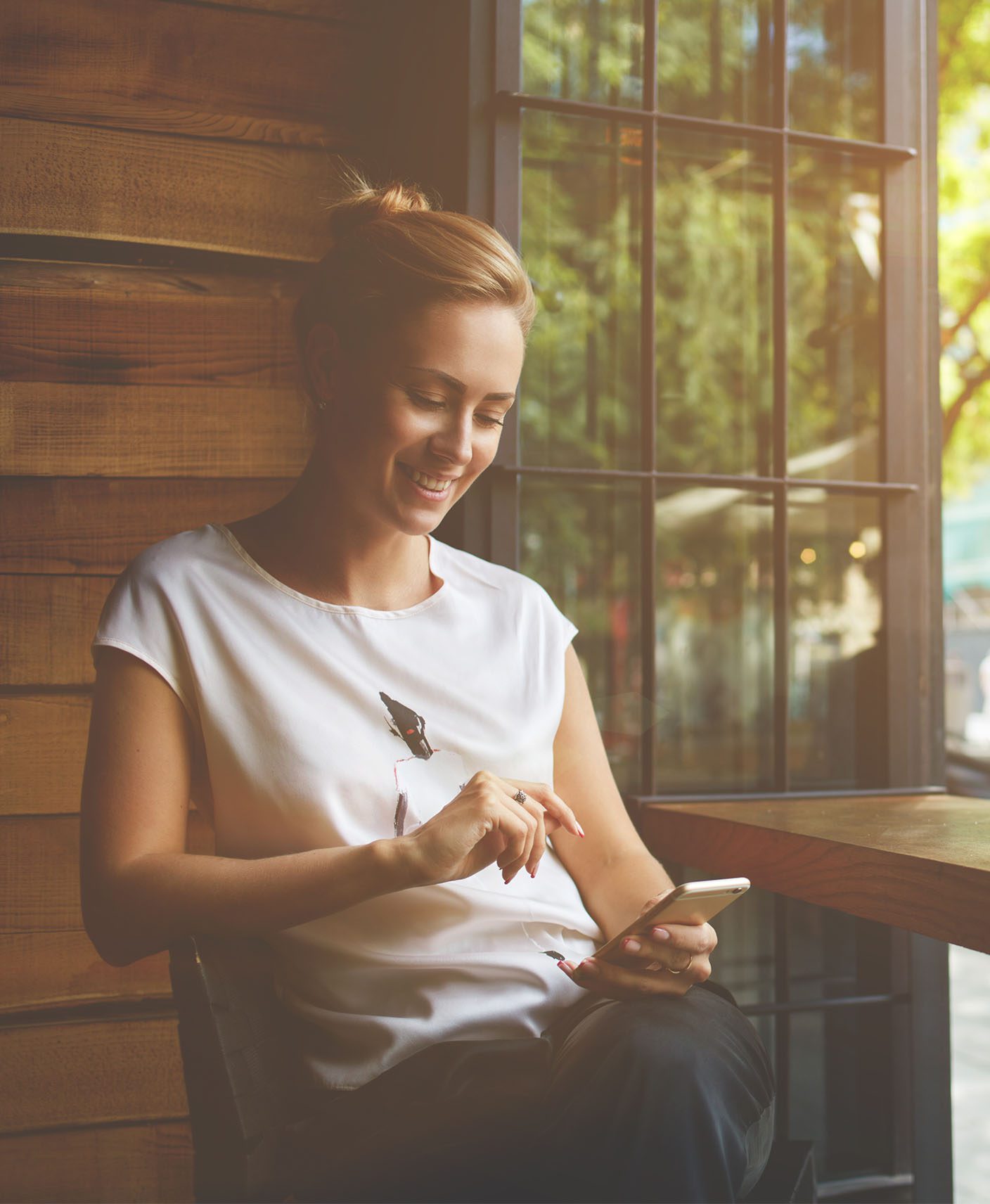 Young woman on mobile device | Stay Well Hotel Rewards