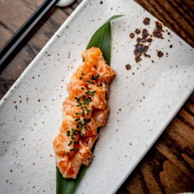 Plated dish of finely chopped salmon tartare garnished with herbs