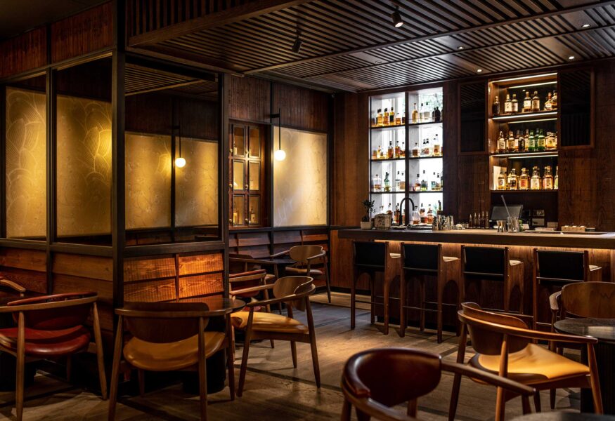 The Malt Lounge and Bar, a dimly lit, modern bar with a wooden counter, high chairs