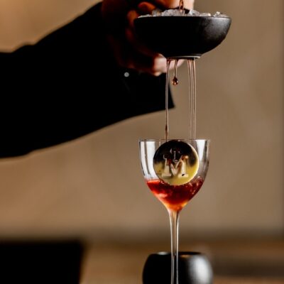 red cocktail into a coupe glass