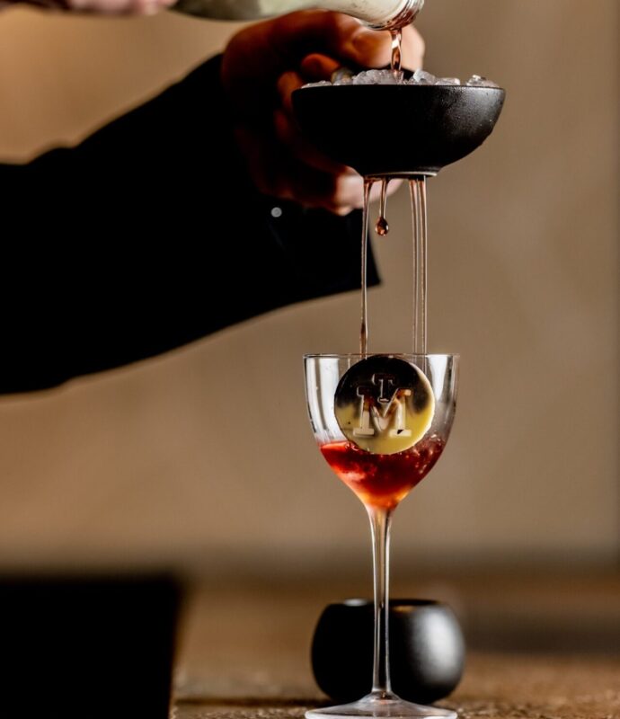 red cocktail into a coupe glass