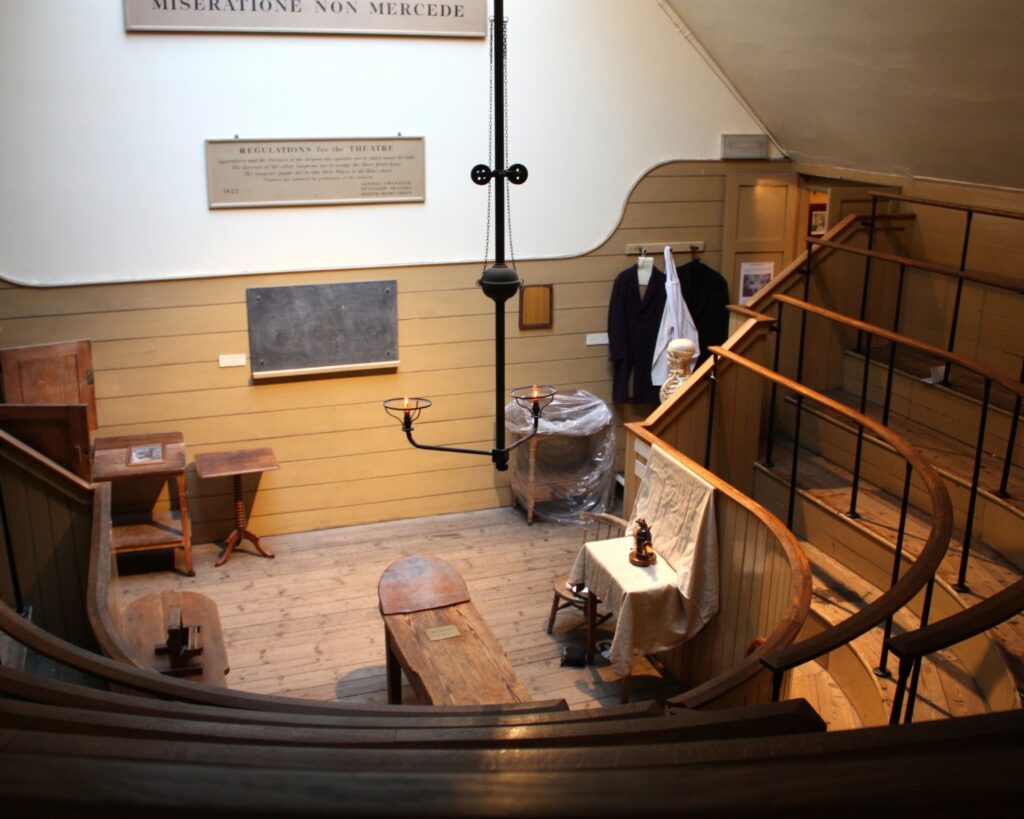 Historic operating theatre featuring wooden seating and antique surgical equipment