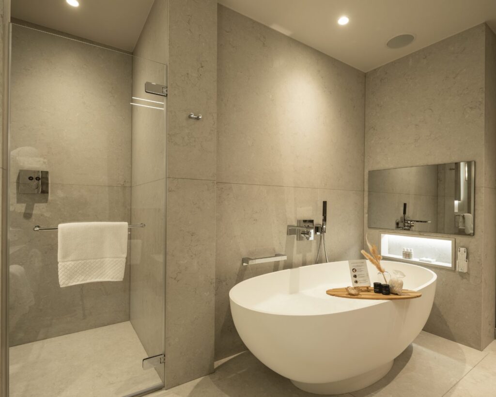 Luxury hotel bathroom with integrated television beside a deep soaking bath.