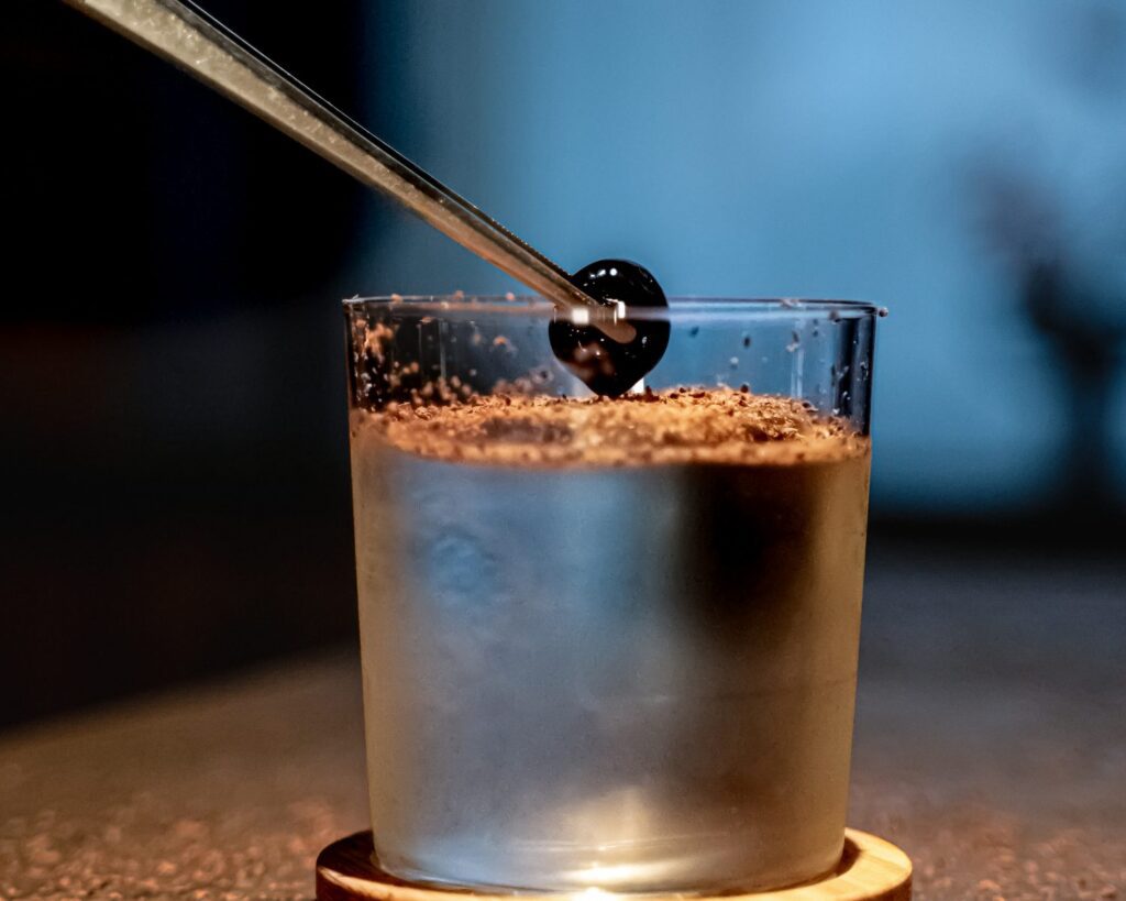 The final flourish of garnish is applied to a premium cocktail within The Malt Lounge whisky bar in London.