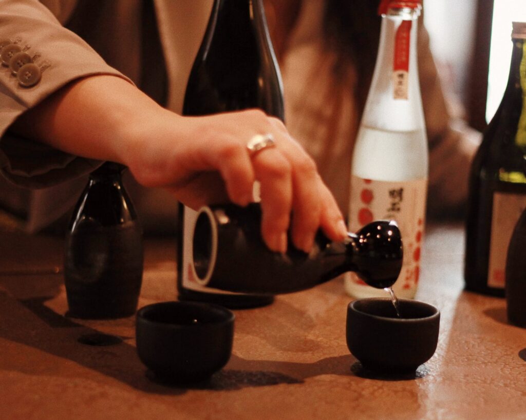 Sake being poured into a cup at The Malt Lounge & Bar, part of The Prince Akatoki hotel.